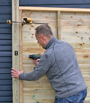 Hörnstolpar skruvas fast i bakramen på förråd Hörnstolpen skruvas fast i bakramen på förrådet